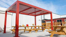 A cozy seating nook with two chairs sits peacefully under a white Structureworks Element Trex Pergola on a standalone raised deck in a grassy yard