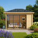 A cozy wood-paneled GardenHouse24 USA Pavilion ALU 44B Garden Room with large sliding glass doors and a modern sofa set