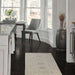 A dining area with sleek gray chairs is grounded by Momeni Anatolia Indoor Rug - ANA-5 Beige