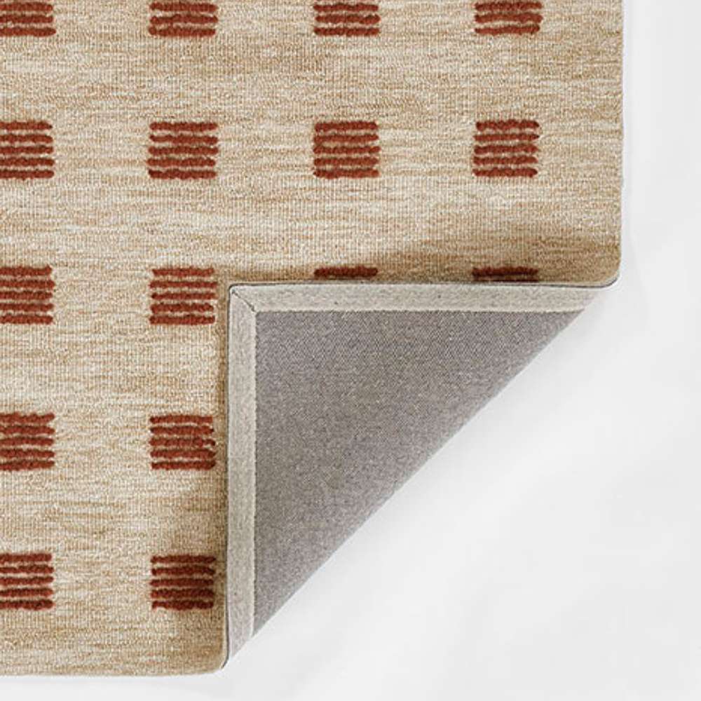 A flipped corner view of Momeni Archer Indoor Rug - ARC-1 Rust highlighting the durable gray backing