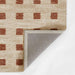 A flipped corner view of Momeni Archer Indoor Rug - ARC-1 Rust highlighting the durable gray backing