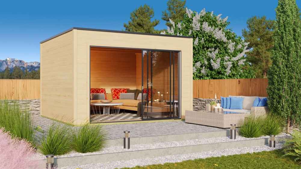 A landscaped backyard scene features the GardenHouse24 USA Q Bic ALU 44A Garden Room furnished with cozy seating and surrounded by greenery and a mountain backdrop