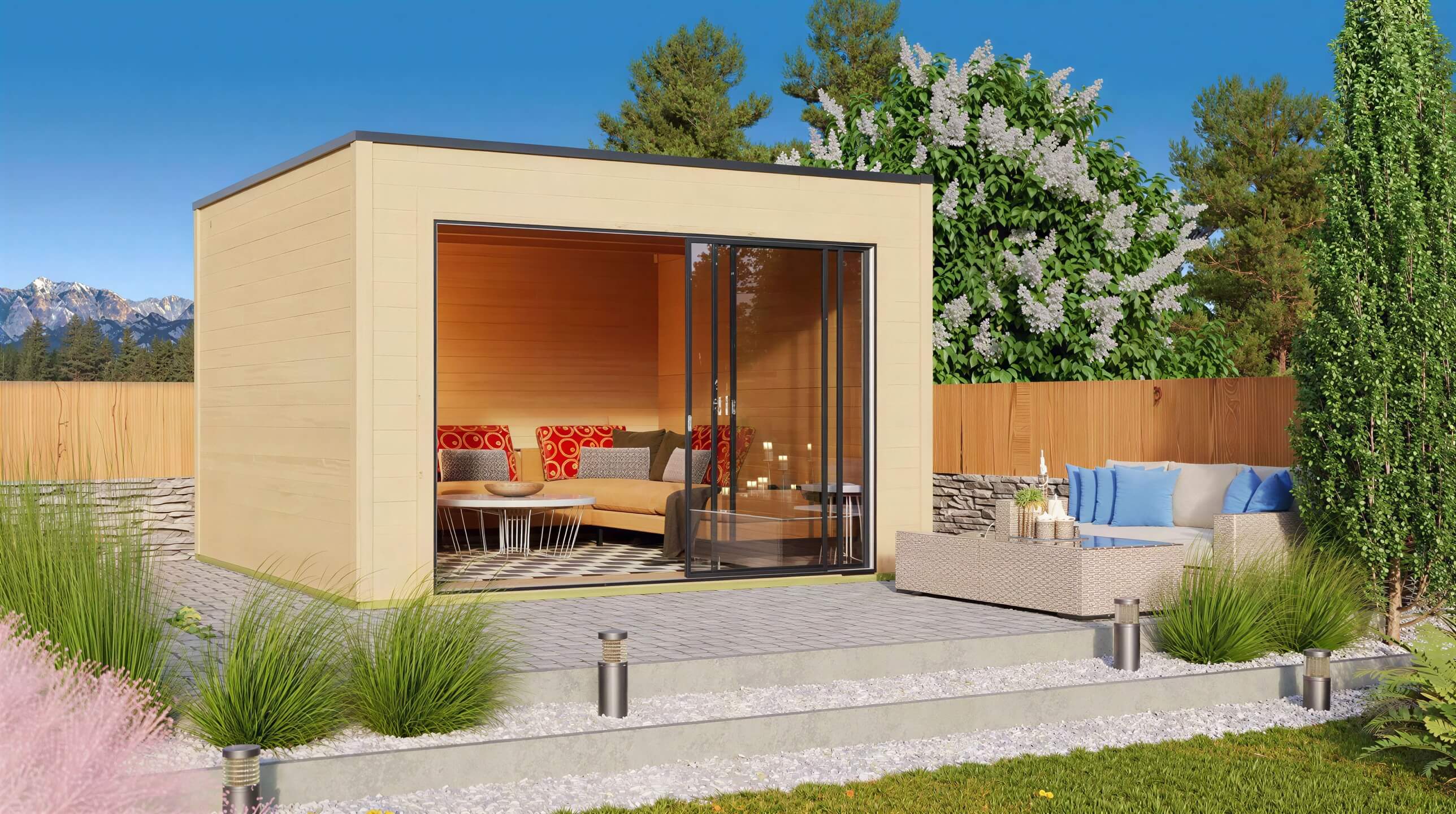 A landscaped backyard scene features the GardenHouse24 USA Q Bic ALU 44A Garden Room furnished with cozy seating and surrounded by greenery and a mountain backdrop