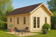 A light wood cabin with a dark roof sits on a grassy lawn with two black patio chairs and potted plants outside, showcasing the GardenHouse24 USA Farum 70 Garden Room