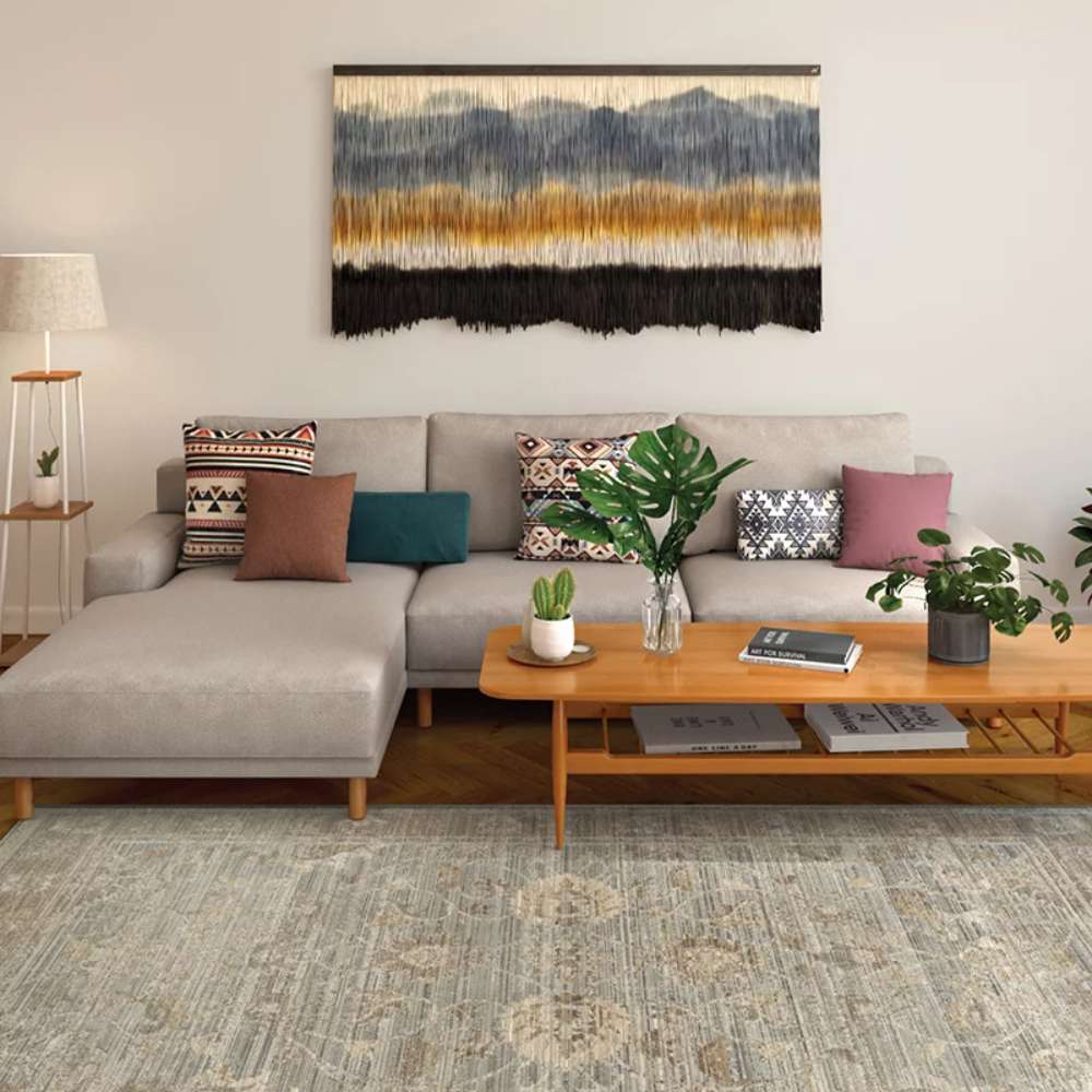 A living room setup featuring Couristan Fez Indoor/Outdoor Rug - Palais/Storm Grey, styled under a sofa, coffee table, and wall art
