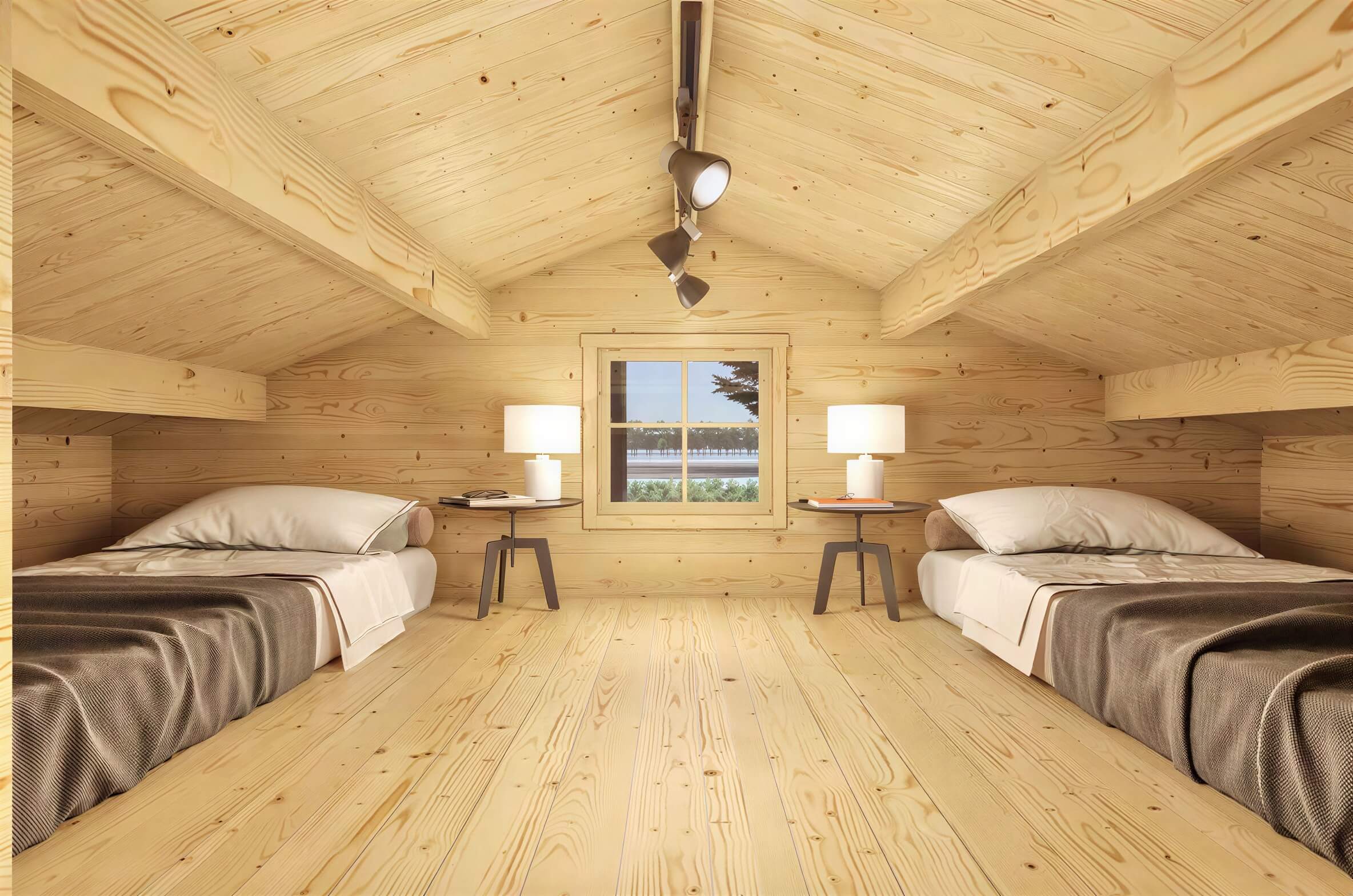 A loft bedroom with twin beds and two small nightstands sits under a peaked ceiling in the Sawmill Structures Edwin Lake House 70MM Garden Room