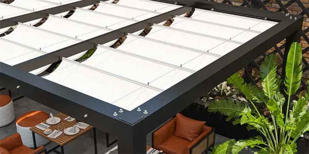 A modern black-framed Structureworks Breeze Aluminum Pergola with white retractable canopy panels shades an elegant restaurant patio with orange seating