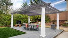 A modern dining setup with gray chairs rests on a wooden deck under a two-tone Structureworks Trex Pergola in a lush backyard