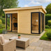 A modern light-wood GardenHouse24 USA ALU Concept 70G Garden Room with black-trimmed glass doors and windows, set on a paved patio surrounded by greenery