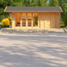 A modern version of the GardenHouse24 USA Konrad 44 B Garden Room showcases a sleek flat-roof design with expansive windows and a stylish outdoor lounge setup