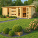 A modern wooden garden house with large windows and a sleek flat roof stands in a lush green yard, showcasing the GardenHouse24 USA Dundee 70C Garden Room as a stylish outdoor retreat