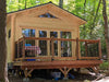 A raised deck with black railing leads to the glass double doors of the Sawmill Structures Edwin Lake House 70MM Garden Room