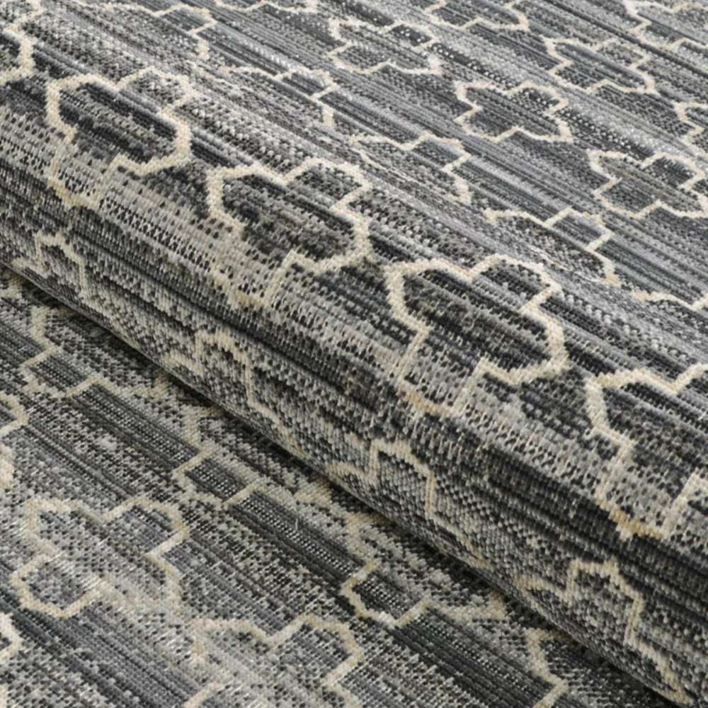 A rolled section of Couristan Fez Indoor/Outdoor Rug - Riad/Tobacco reveals its durable woven texture and intricate design