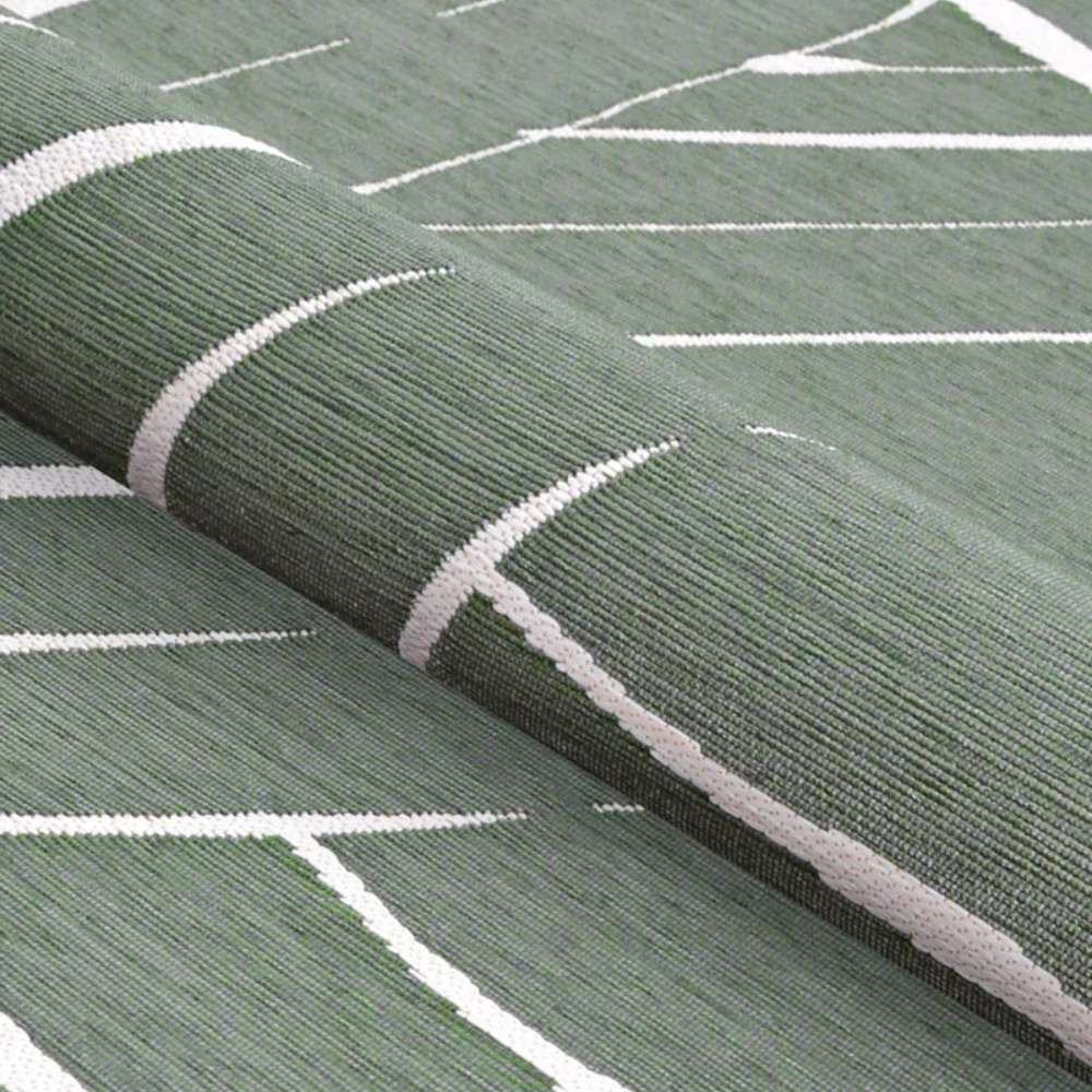 A rolled view of Couristan Dolce Indoor/Outdoor Rug - Parquet/Fern reveals its flexible texture and leaf-like line patterns