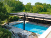 A sleek, modern poolside area with loungers shaded by a long, dark-colored Structureworks Windsor Aluminum Patio Cover