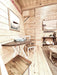 A small dining area with a round wood table and two stools sits beside a ladder staircase inside the Sawmill Structures Ontario Grand Loft 107 SD Garden Room