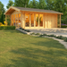 A spacious wooden GardenHouse24 USA Konrad 44 B Garden Room with a pitched roof, large glass doors, and a cozy, plant-filled interior