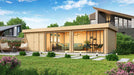 A stylish GardenHouse24 USA ALU Concept 70L Garden Room sits in a landscaped yard, with floor-to-ceiling windows revealing a cozy interior with green sofas and a dining set