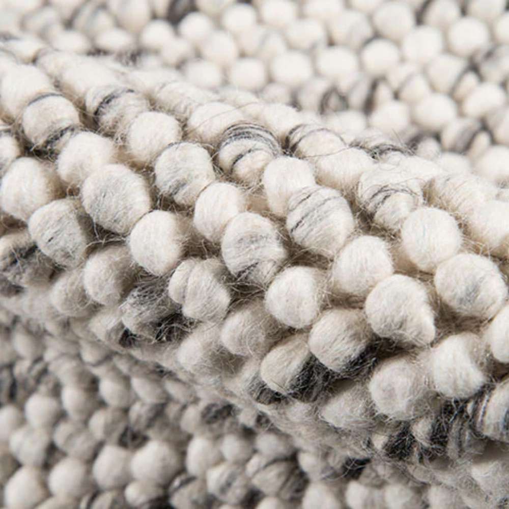 A textured macro shot of Momeni Andes Indoor Rug - AND-8 Ivory revealing its thick, plush wool pile