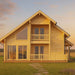 A warm, golden sunset highlights the GardenHouse24 USA Olivia 90 Garden Room’s clean wooden facade, twin balconies, and full-length windows