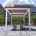 A white Structureworks Pavilion Trex Pergola with a red roof shades a round planter and bench setup in a city square