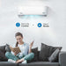 A woman sits comfortably on a sofa using the Senville 9000 BTU Mini Split Air Conditioner - Heat Pump - SENL09CD110V in silent mode with the remote control in hand
