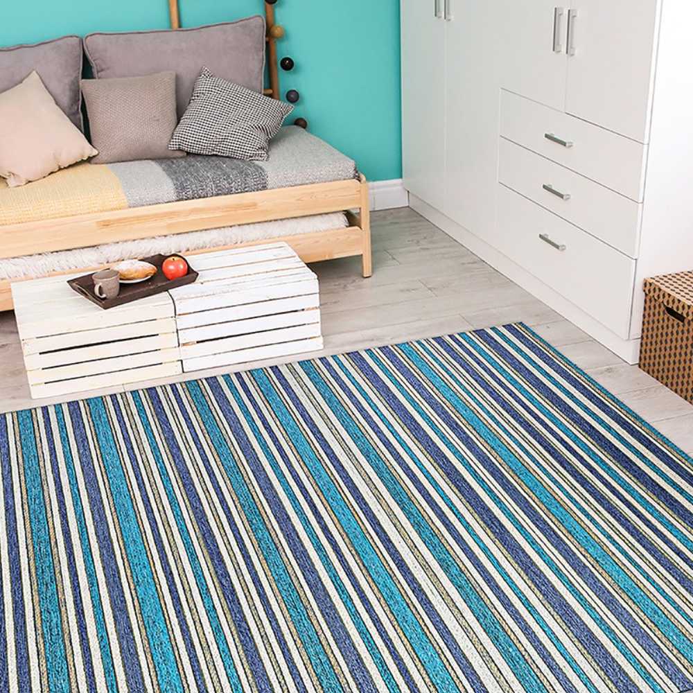 A bright indoor room with a daybed and white furniture features the Couristan Cape Indoor/Outdoor Rug - Brockton/Cobalt-Teal bringing color and warmth to the floor
