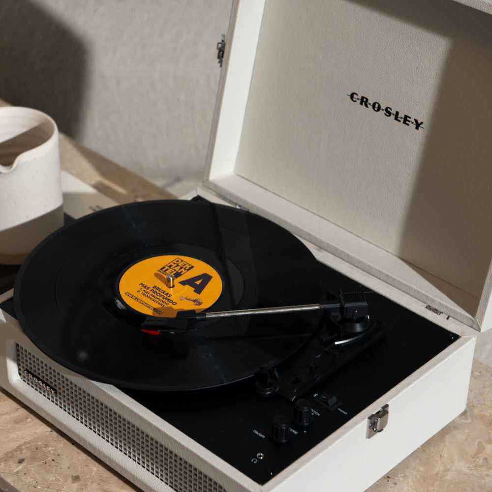 A close-up highlights the Crosley Mercury Portable Turntable - Cream Croc's three-speed playback, adjustable pitch control, and full-range stereo speakers