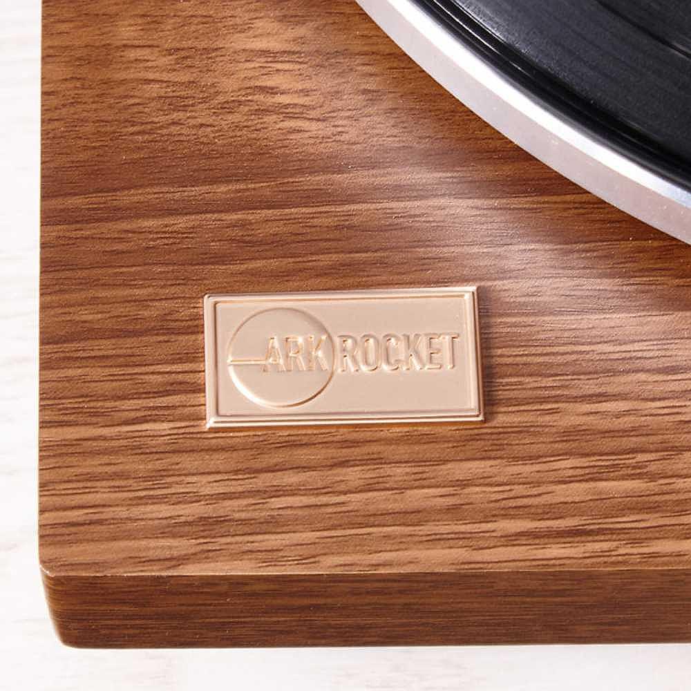 A close-up image of Arkrocket Cassini Bluetooth Vinyl Turntable Record Player 40 Watt Stereo Bookshelf Speakers logo plate