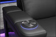 A close-up of an illuminated cup holder of the Valencia Monza Pillow Top Carbon Fiber Home Theater Seating