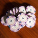 A close-up of several $1 BBO Poker Tables 500-Piece Classic Casino Poker Chips in light purple