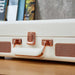 A close-up of the Arkrocket Curiosity Suitcase Bluetooth Turntable (Cream Rose Gold) handle and latch, showcasing its cream-colored exterior and rose gold metal accents