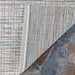 A close-up of the Couristan Cape Indoor/Outdoor Rug - Falmouth/Ivory-Coral with one corner flipped to show the detailed weave and backing material