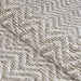 A close-up of the Couristan Cape Indoor/Outdoor Rug - Marion/Light Brown-Ivory shows a textured zigzag pattern woven with light brown and ivory threads