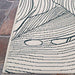 A close-up of the Couristan Castille Indoor/Outdoor Rug - Palma/Petrol shows detailed stitching of the leaf pattern along the edge
