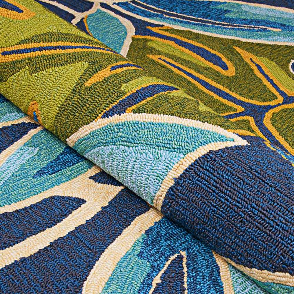 A close-up of the Couristan Covington Indoor/Outdoor Rug - Areca Palms/Brown-Forest Green reveals its tightly hooked loops and vibrant leaf pattern in ocean blues and greens