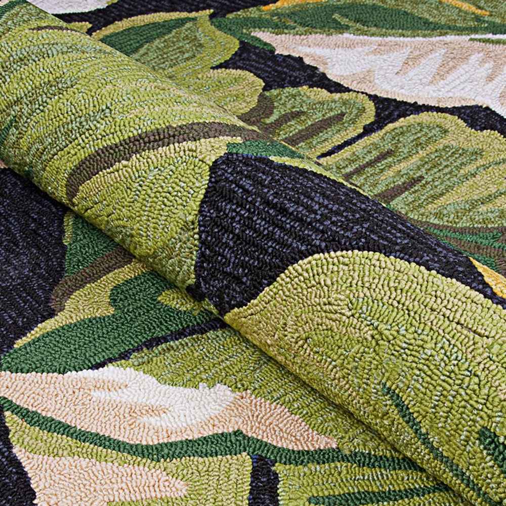 A close-up of the Couristan Covington Indoor/Outdoor Rug - Rainforest/Forest Green-Black shows its thick looped texture and vibrant tropical leaf pattern