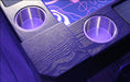 A close-up of the Game Theory Tables Origins Lit table corner, featuring purple LED lighting and polished cup holders against a dark wood finish