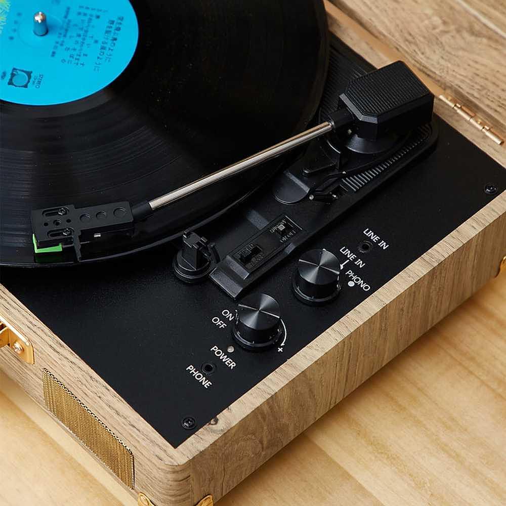 A close-up of the control panel on Arkrocket Curiosity Suitcase Bluetooth Turntable (Wood Grain) showing knobs and switches for different functions