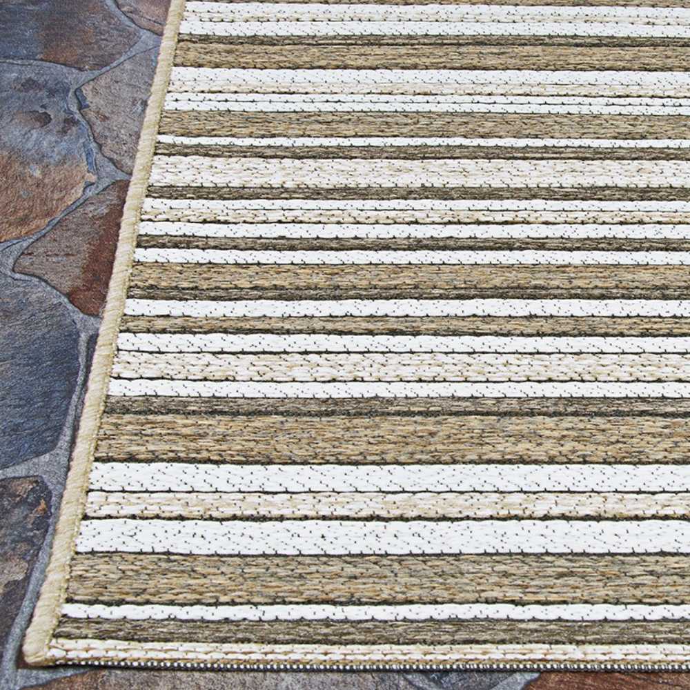 A close-up of the corner of the Couristan Cape Indoor/Outdoor Rug - Brockton/Light Brown-Ivory placed on stone flooring