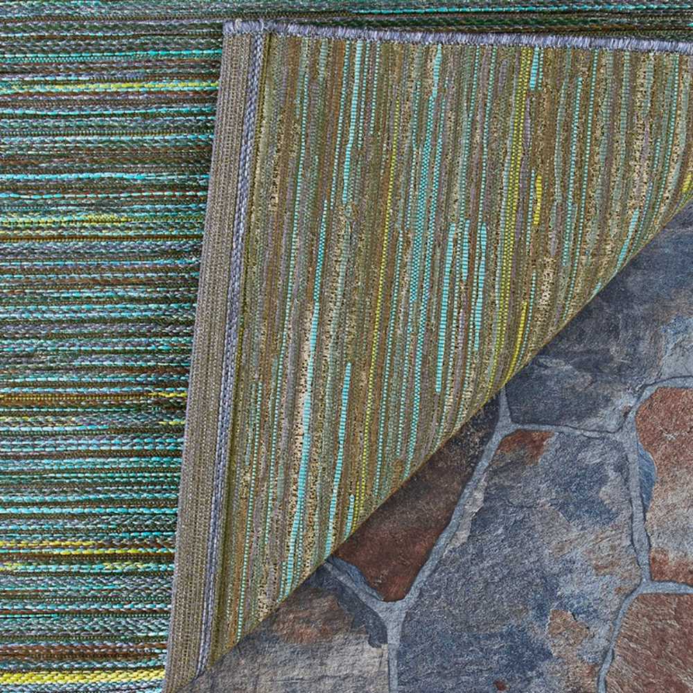 A close-up of the corner of the Couristan Cape Indoor/Outdoor Rug - Hinsdale/Teal-Cobalt shows its underside folded to reveal the tight weave and texture