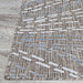 A close-up of the edge of the Couristan Charm Indoor/Outdoor Rug - Aurora/Twig showcases its tightly bound border and intricate patterned surface