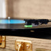 A close-up of the stylus needle on Arkrocket Curiosity Suitcase Bluetooth Turntable (Wood Grain) as it plays a vinyl record