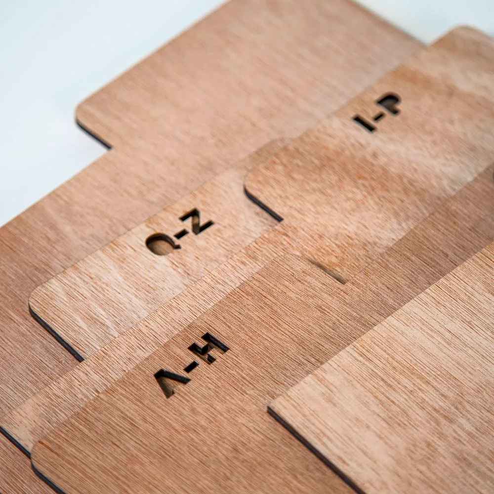 A close-up of the wooden Crosley A-Z Crate Dividers - Natural, showcasing the laser-cut alphabetical labels on the tabs