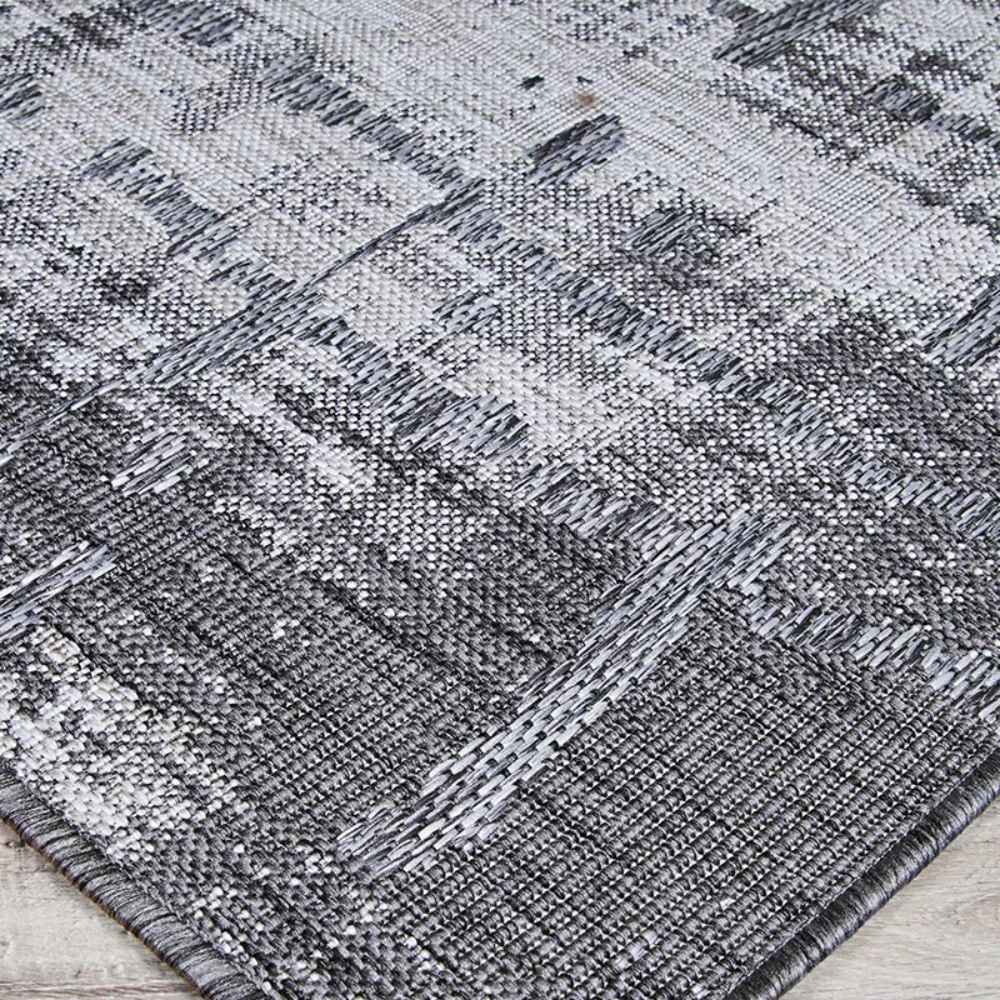 A close-up shot reveals the tightly woven texture and detailed pattern of the Couristan Charm Indoor/Outdoor Rug - Tiverton/Anthracite-Light Grey