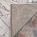 A close-up shows the corner of the Couristan Castille Indoor/Outdoor Rug - Palma/Rouge flipped to reveal its backing and placement on a stone surface