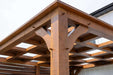 A close-up view of the Brookside Timber Frame Timber Resort Pergola highlights its detailed mortise and tenon joinery