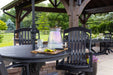 A close-up view of the Brookside Timber Frame Timber Retreat Pavilion showcases a cozy seating area with a rustic table set for refreshments