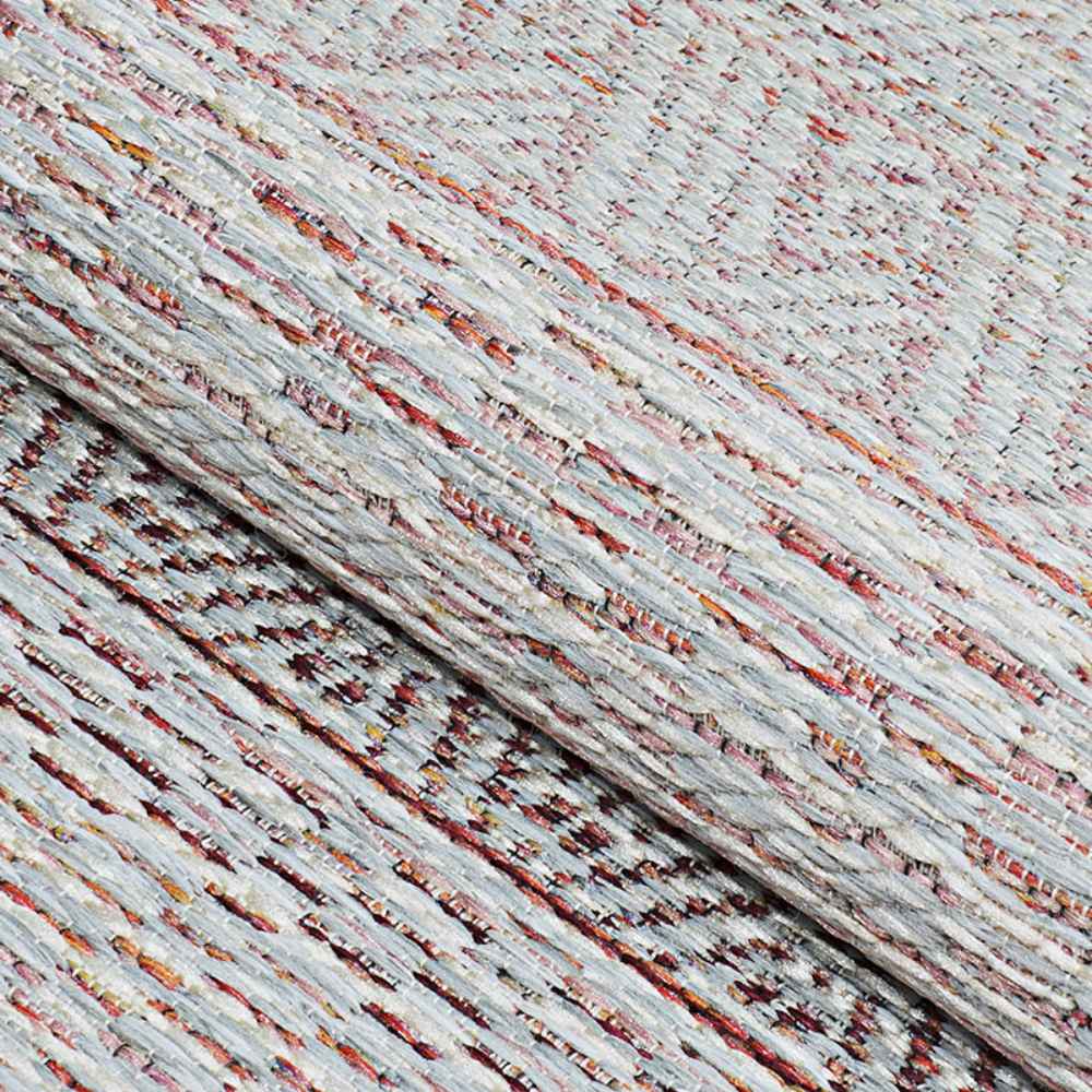 A close-up view of the Couristan Cape Indoor/Outdoor Rug - Gables/Hibiscus shows its textured woven surface with soft hibiscus tones and multicolored threads