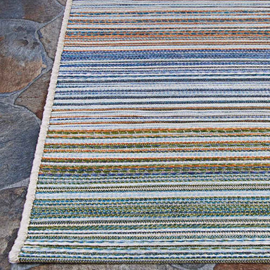A close-up view of the Couristan Cape Indoor/Outdoor Rug - Shoreham/Ivory-Multi reveals detailed woven stripes in blue, green, and orange